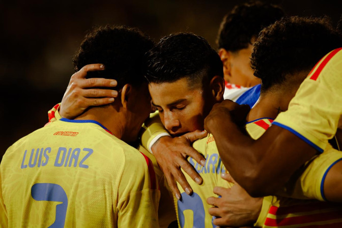 Jugadores de la Selección Colombia, incluyendo a Luis Díaz, celebran un gol abrazados con uniformes amarillos.