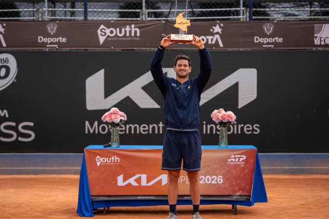 Tenista celebra levantando el trofeo del KIA Open ATP Challenger 75, con forma del mapa de Colombia, en cancha de arcilla.